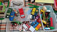 Wide view showing assortment of vintage diecast cars, miniature vehicles, Brio style train cars, bins and boxes