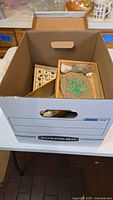 Box filled with multiple smaller boxes containing stones, shells, minerals, and geodes.