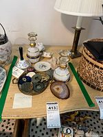 Overview of the lot showing two painted glass bottles, metal bell, geode slice, pin cushion, coral, and metal tray with assorted objects.