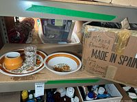 Two Mikasa ceramic dishes with orange floral pattern along with two vintage etched clear glasses and orange sugar bowl.