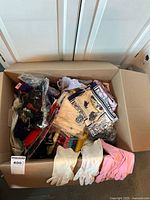 Box showing multiple textile items including gloves, scarves, and collars