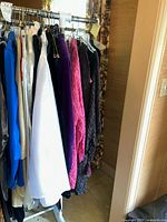 Rack of colorful ladies clothing including blouses and jackets in multiple colors