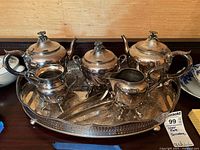 Full shot of silver plated tea and coffee service including tray, coffee pot, teapot, cream pitcher, sugar bowls, sugar cube tongs
