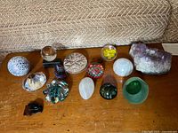 Overview of all glass paperweights, crystals, and stones on wooden surface