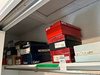 Shelf with stacked shoe boxes from Mephisto, Gabor, Ara, Capezio, Beautiful Feel, Privo, and other brands.
