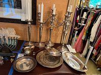 Overview of two candlesticks, candelabra, trays, dishes, jugs and snuffer on table
