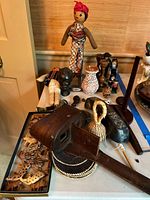 Overview of the lot showing stereoscope, dolls, animal figurines in a tray, decorative jug, and candlesticks on a table.