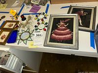 Overview of the lot showing two framed fabric art pieces, two pressed flower artworks, and multiple glass suncatchers arranged on a white surface.
