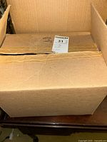 Closed cardboard box containing the vintage books lot, exterior view.