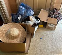 Boxes containing hats, mink fur strips, and bags arranged on floor