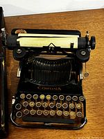 Front view of Corona Standard typewriter on wooden surface
