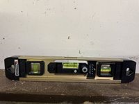 Front and top view of Benchmark AcuraLevel 12-inch level placed on a flat surface showing three bubble vials and the attached ruler along the side.