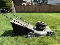 Side view of the MTD Pro lawn mower with fabric catcher bag in green grass.