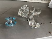 Photo showing all three figurines: a blue clam shell with pearl, a clear mini dachshund dog, and a clear rose.