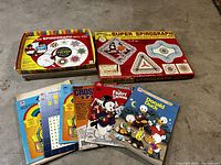 Photo showing Kenner Super Spirograph kit box and Spirograph refill kit box along with six vintage coloring and activity books.