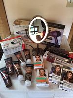 Photo of Vidal Sassoon, Revlon, and other hair dryers and curling iron boxes along with John Frieda shampoo and conditioner tubes and Clairol root touch-up packs