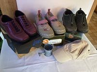 Full lot view showing three pairs of shoes, cap, and tin watering can