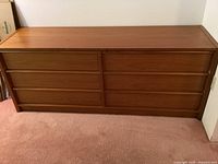 Full view of the solid wood dresser showing six drawers and natural wood finish.