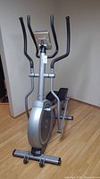 Full front view of elliptical trainer showing digital display, dual handlebars, and flywheel.