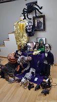Full lot shown with various Halloween decorations and costumes including spider, pumpkin figure, animatronic zombie, wigs, and props.