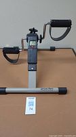 Full view of Proactive Physiotherapy pedal exerciser showing pedals, digital counter, and frame on table.