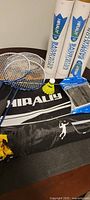 Four badminton rackets, shuttlecocks, net tubes, carrying case