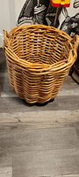 Full view of large woven wicker basket showing round shape, thick wicker weave, and handle on side
