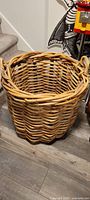Front and side views of a large handwoven wicker basket showing thick, robust weave and sturdy handles.