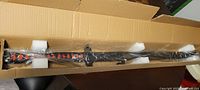 Katana sword in original cardboard box with foam padding, wrapped in plastic protecting the sword and sheath.