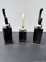 Three Vacheron Constantin watch display stands with black glass bases and brass/wood base trims with visible surface scratches