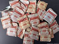 Overview of approximately 22 pieces of vintage G-S Flexo Crystals in original worn paper envelopes, various sizes.