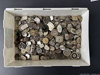 Overhead view of bin containing assorted movements and dials