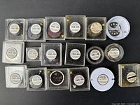 Photo of multiple Citizen watch movements in labeled plastic cases on black background.