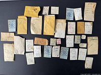Photo showing 31 assorted small paper envelopes with handwritten notes, indicating vintage Swiss watch parts including Tudor and other types.