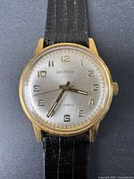 Close-up photo of the watch face showing the brand Westclox, silver dial with gold-tone numbers, and leather strap.