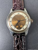 Close-up front view of the watch face showing the dial, Arabic numerals, and watch hands with the text 'MARK 15 JEWELS' visible.