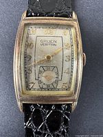 Close-up front view of vintage Gruen Verithin watch face showing rectangular gold-tone case, silver dial with gold Arabic numerals, and sub-seconds dial.