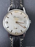 Close-up view of the watch face showing the Royalville brand, crown logo, 17 Rubis text, date window, and markers.