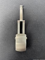 Top view of a vintage Omega stainless steel men’s watch clasp with Omega logo on the surface.