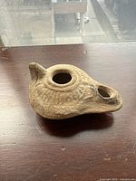 Side view showing overall shape, nozzle spout, and handle knob