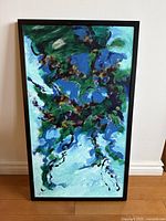 Front view of the framed abstract painting leaning against wall