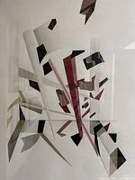 Close-up of artwork detail showing angular shapes in red, black, beige and olive