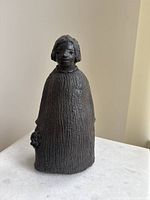 Front view of black patinated sculpture showing full figure and textured finish
