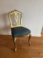 Front view of the Florentine gilt wood chair showing ornate carved backrest and upholstered seat.