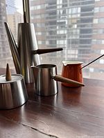 Full view of coffee pot, creamer and sugar bowl arranged on windowsill