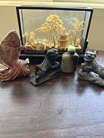 Overview showing glass case diorama, stone snuff bottle, fish carving and two foo dogs
