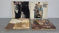 Four album covers: Sticky Fingers (Rolling Stones), Yesterday And Today (Beatles), Led Zeppelin II, Sgt. Pepper's Lonely Hearts Club Band (Beatles)