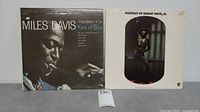 Front cover of Miles Davis Kind of Blue and Sammy Davis Jr. Portrait LP albums side by side.