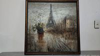 Full view of the framed painting showing the Paris street scene and Eiffel Tower.