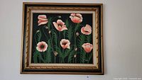 Full front view of framed painting showing pink poppies on black background with ornate gold frame